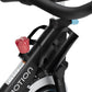 Black and white stationary indoor exercise bike with red resistance knob and blue indicator light on frame