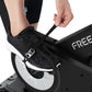 Black and white Freemotion stationary bike pedal with foot strap, worn by model on exercise bike