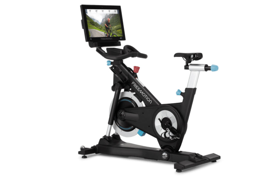 Black and white stationary exercise bike with blue accents, equipped with tablet display showing cycling video, on white back