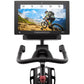 Black stationary exercise bike with curved handlebars and tablet display screen showing mountain biker on trail, viewed from 