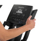 Freemotion e10.9b black elliptical machine console with digital display, held by model's hand on white background