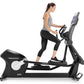 Woman using black Freemotion e22.9 elliptical with digital display, worn gray tank top and black capris