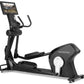 Black Freemotion e22.9 elliptical with digital touchscreen display showing workout content, padded foot pedals, handlebar gri