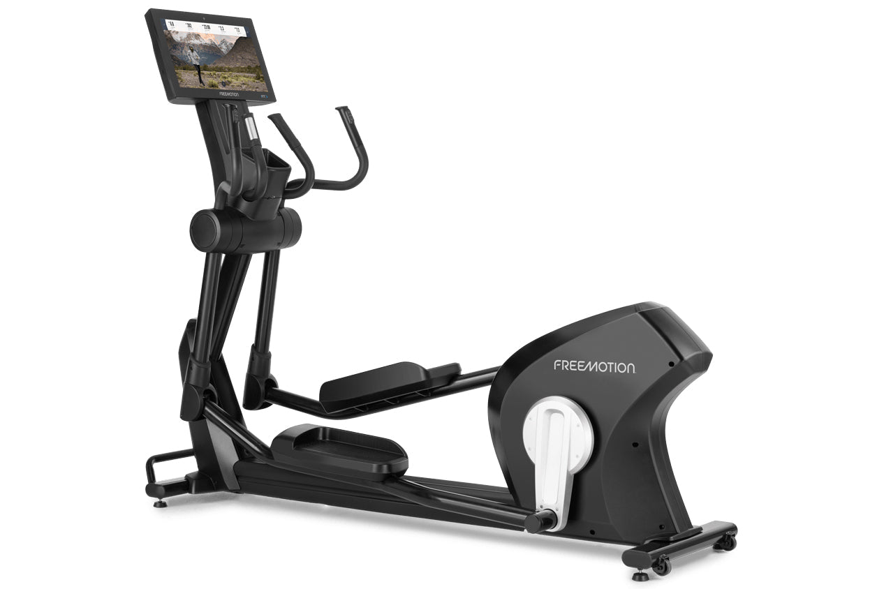 Black Freemotion e22.9 elliptical with digital touchscreen display showing workout content, padded foot pedals, handlebar gri