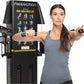 Woman using black Freemotion Genesis Dual Cable Cross Lite machine with exercise diagram display, holding handles in chest fl