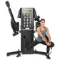 Freemotion G424 Dual Cable Cross Lite machine in black with instruction chart, woman demonstrating exercise movement with cab