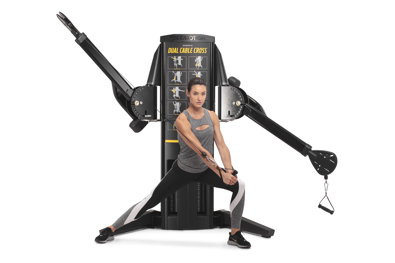 Woman using black Freemotion Genesis Dual Cable Cross machine with dual adjustable arms and instruction panel, shown on white