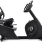 Black recumbent exercise bike with curved seat, digital console mounted on handlebar, and large wheel base on white backgroun