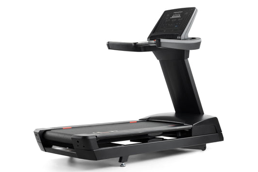Black Freemotion t10.9b REFLEX treadmill with digital display console, handrails, and cushioned running deck on white backgro