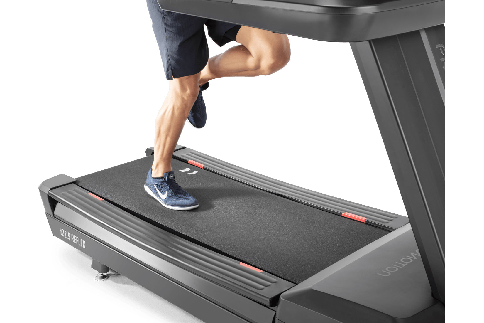 Person running on gray Freemotion t22.9 REFLEX treadmill with dark running shorts and navy sneakers