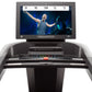 Freemotion t22.9 REFLEX treadmill with gray base, digital display showing fitness video, and control console with buttons on 