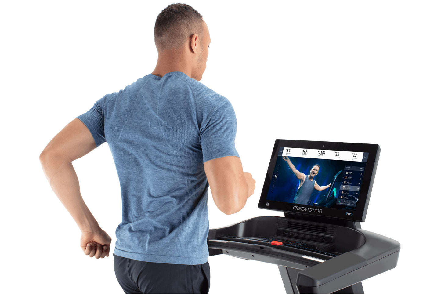 Man wearing blue heather t-shirt running on Freemotion treadmill with touchscreen display showing workout metrics