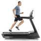 Man running on black t22.9 REFLEX treadmill wearing blue t-shirt and black shorts, white sneakers visible