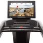 Freemotion t22.9 REFLEX treadmill with black frame, touchscreen display showing runner on rocky landscape, and control panel 