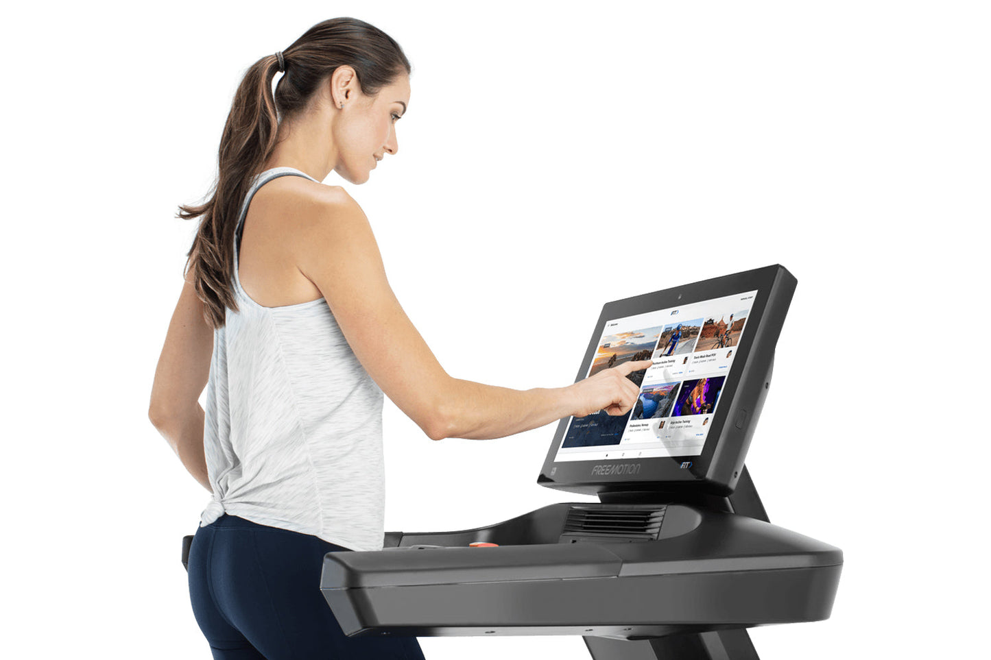 Woman in white tank top and navy pants using Freemotion t22.9 REFLEX treadmill with touchscreen display