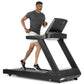 Man running on black Freemotion t8.9b treadmill with digital display, wearing charcoal t-shirt and white shorts