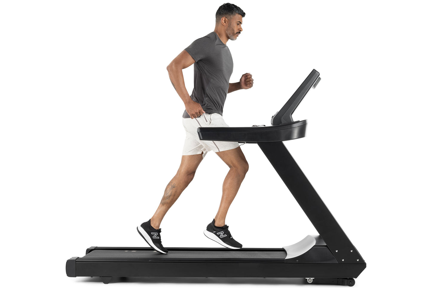 Man running on black Freemotion t8.9b treadmill wearing gray t-shirt and white shorts