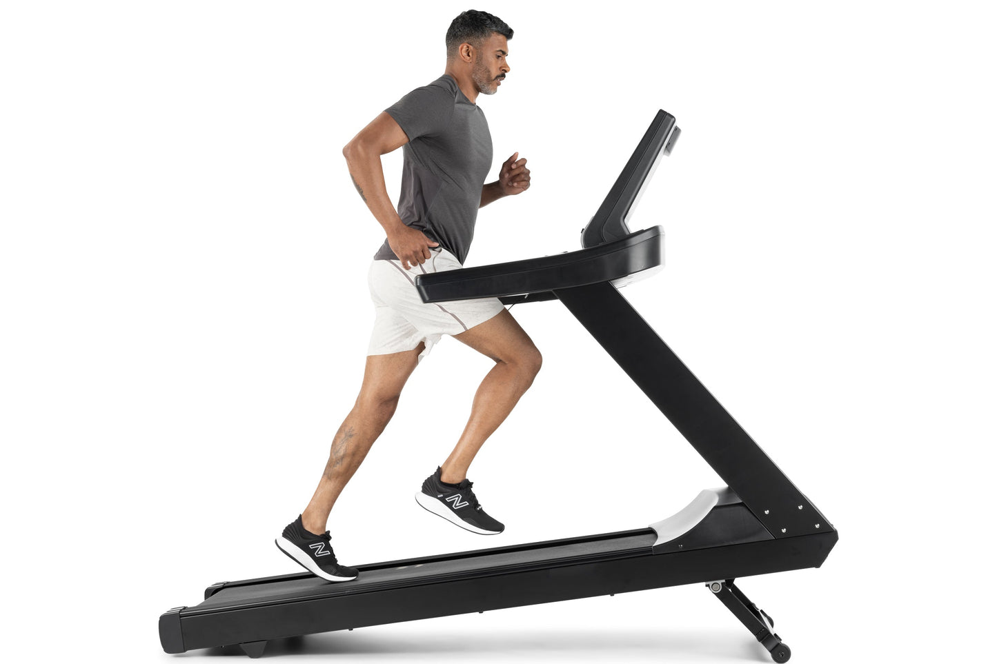Man running on black and white Freemotion t8.9b treadmill wearing gray t-shirt and white shorts