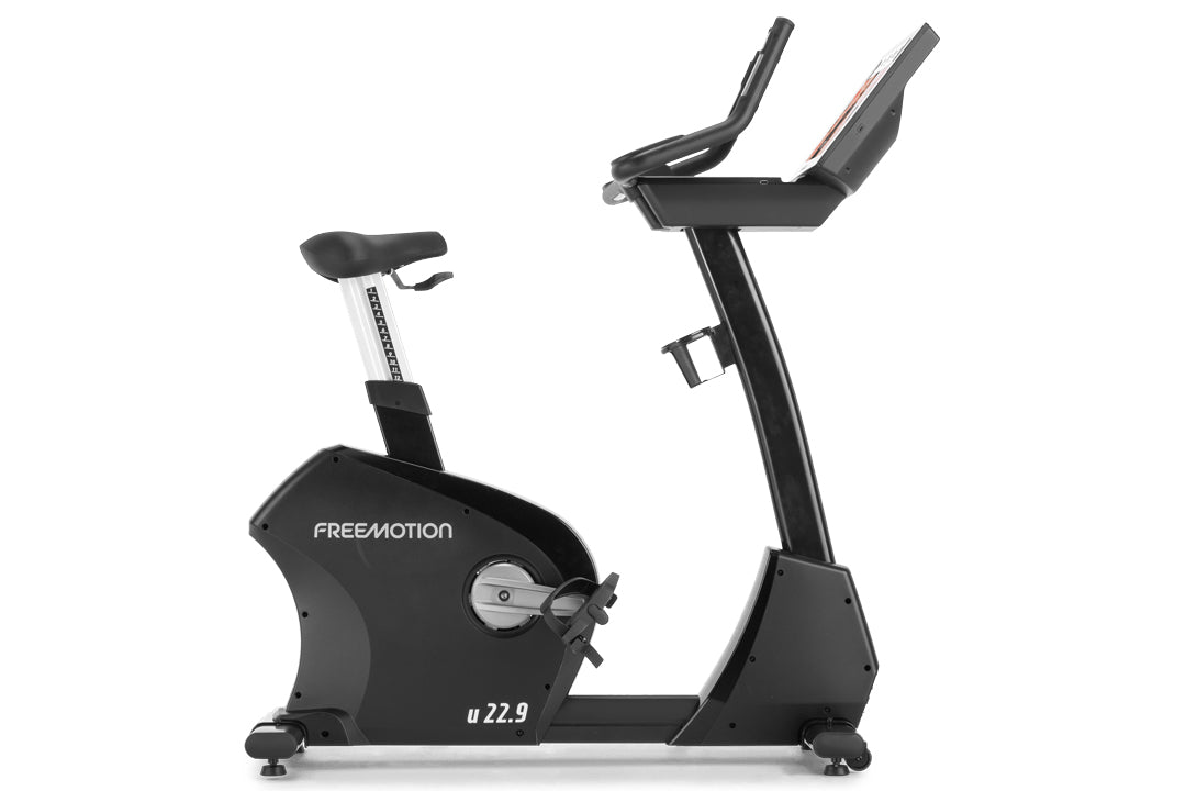Freemotion u22.9 black upright exercise bike with white seat post and dual handlebar grips on white background