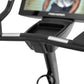 Black upright exercise bike with curved handles, digital display screen, and silver accent details on handlebars