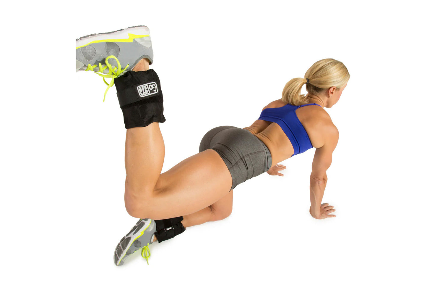 Athlete wearing black adjustable ankle weights with neon yellow straps during plank exercise on white background
