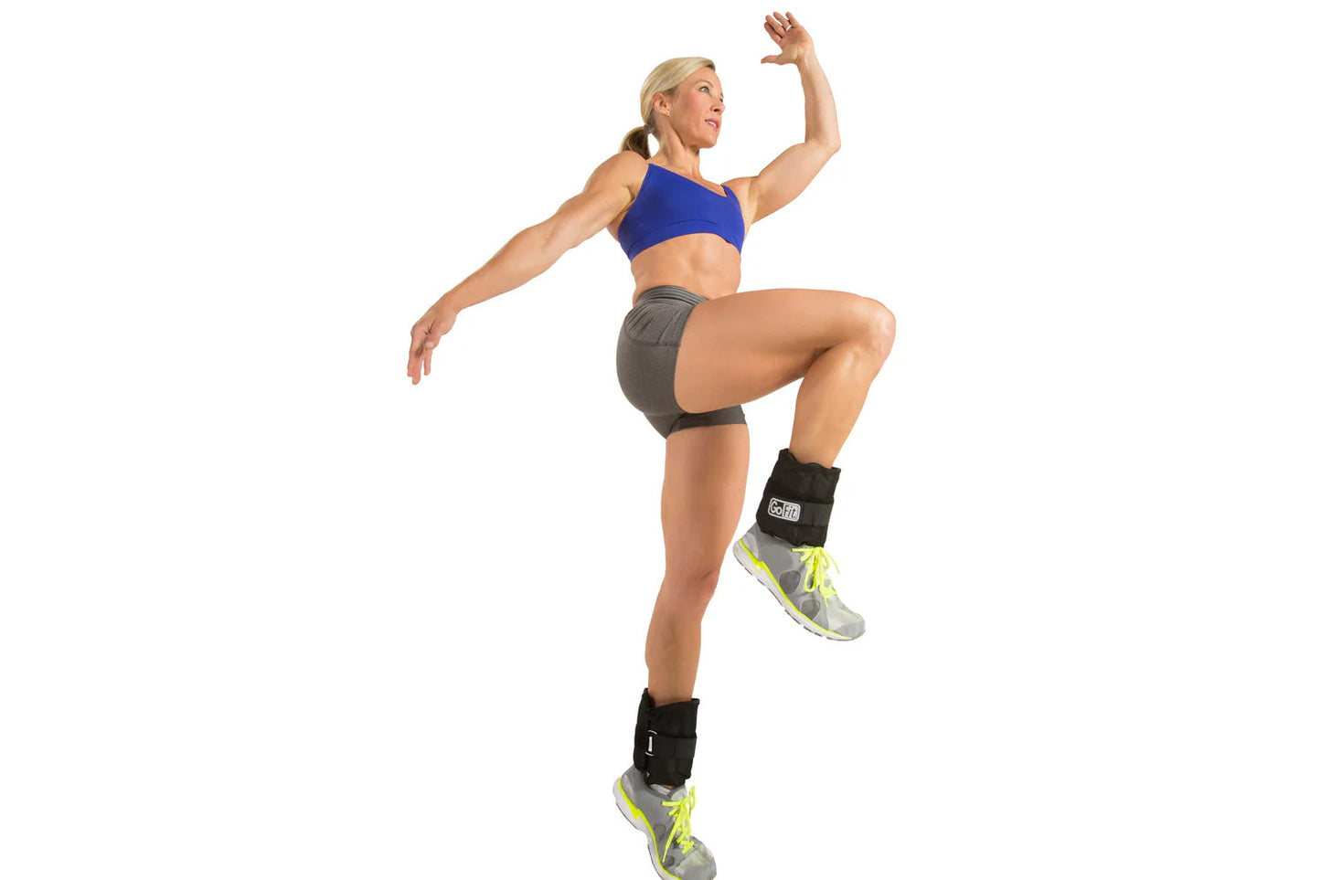 Woman wearing blue sports bra and gray shorts demonstrating adjustable black ankle weights with neon yellow accents while jum