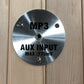 Brushed stainless steel MP3 and aux input jack with 175mV max specification, mounted on wooden panel