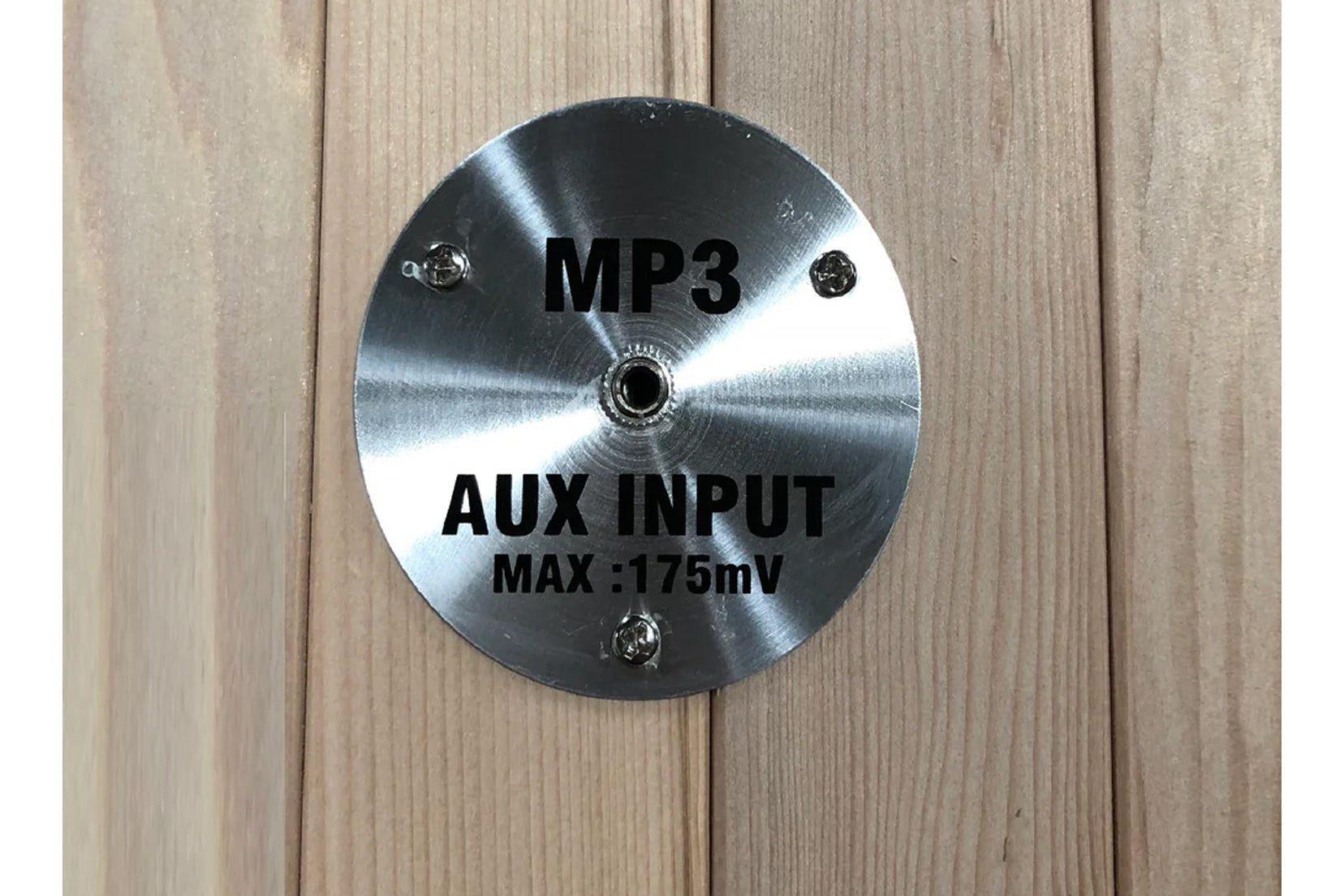 Brushed stainless steel MP3 and aux input jack with 175mV max specification, mounted on wooden panel