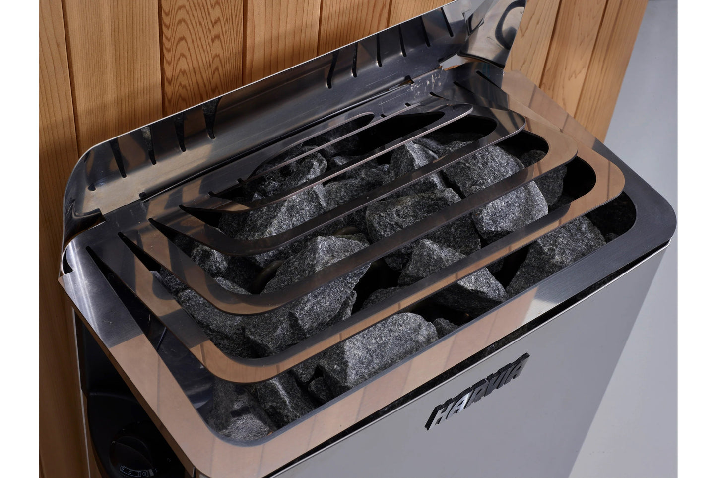 Golden Designs Soria sauna interior with open lid revealing black compartments filled with gray sauna rocks and wood paneling