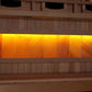 Golden Designs infrared sauna with glowing orange and yellow interior window panels, wood exterior, and Himalayan salt bar fe