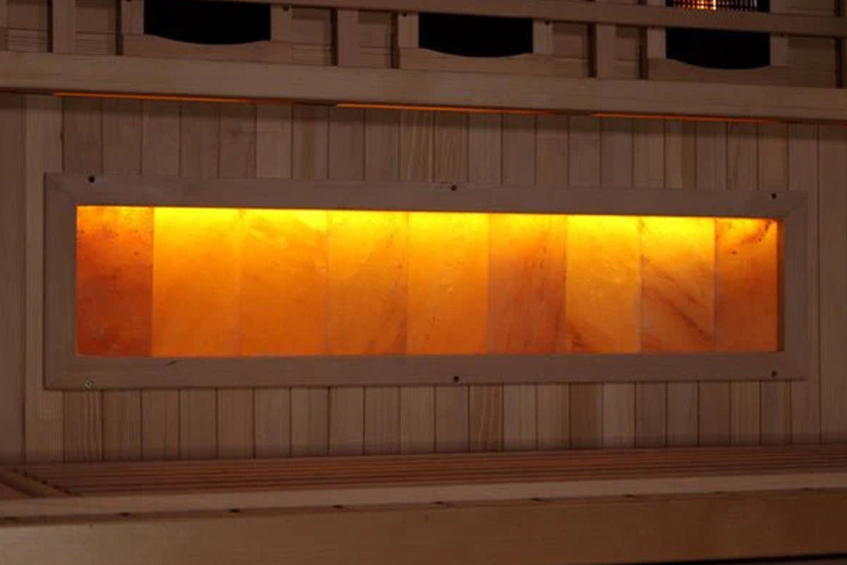 Golden Designs infrared sauna with glowing orange and yellow interior window panels, wood exterior, and Himalayan salt bar fe
