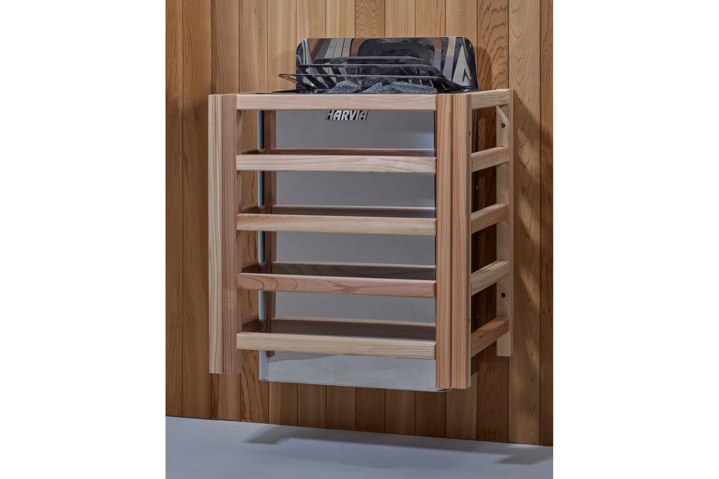 Natural wood sauna heater guard with gray metal panels and multiple horizontal wooden shelves, mounted on wooden wall backgro