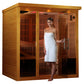 Cedar far infrared sauna cabin with glass door and front panels, woman in white towel standing in doorway, interior featuring