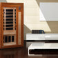 Cedar wood infrared sauna with glass door, black heater panels visible inside, digital control panel, and light wood interior