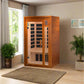 Cedar wood infrared sauna with glass door and black interior panels in home room setting