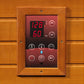 Sauna control panel with wooden frame mounted on cedar wall, displaying digital temperature of 128 degrees and 60 minutes wit