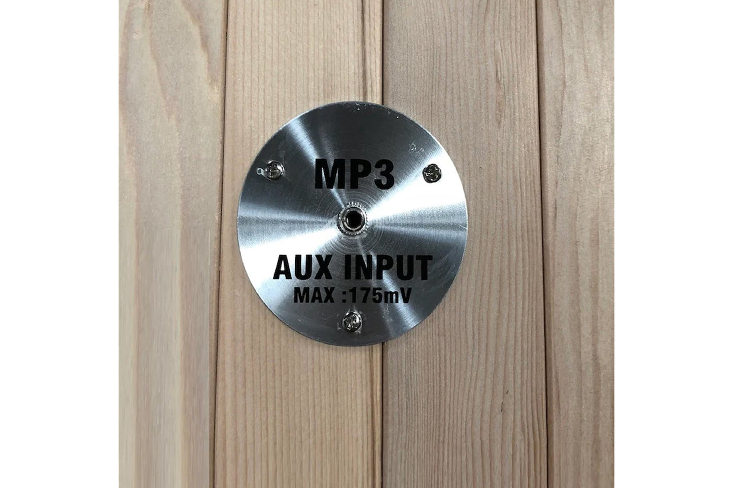 Brushed stainless steel circular control panel with MP3 and AUX INPUT text, mounted on light wood sauna interior