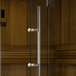Glass sauna door with chrome handles and white porcelain knobs on wood-paneled sauna exterior