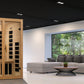 Golden Designs Gracia sauna with natural wood finish and infrared heating panels, displayed in modern living room setting