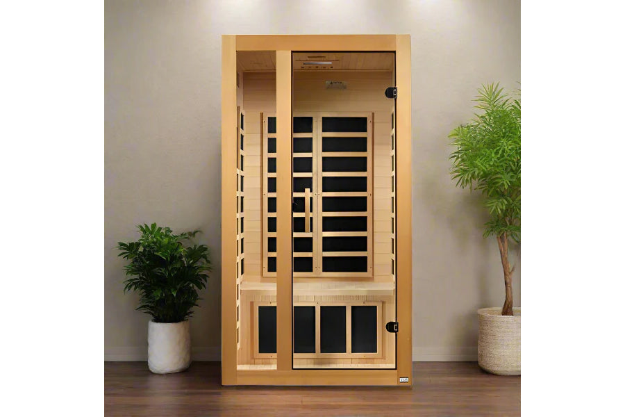 Golden Designs Gracia sauna in light wood with black glass panels, two doors, and infrared heating elements, flanked by potte
