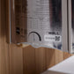 Close-up of product manual and specifications label on sauna packaging, showing technical details, QR code, and "The Wall" br