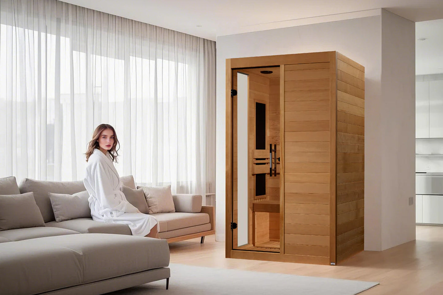 Two-person infrared sauna with golden cedar wood construction and glass door, shown in modern living room with model seated o