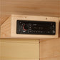 Black digital car stereo with red volume knob mounted in light wood frame inside sauna