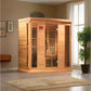Cedar wood infrared sauna cabin with glass front doors and digital control panel, shown in home interior setting