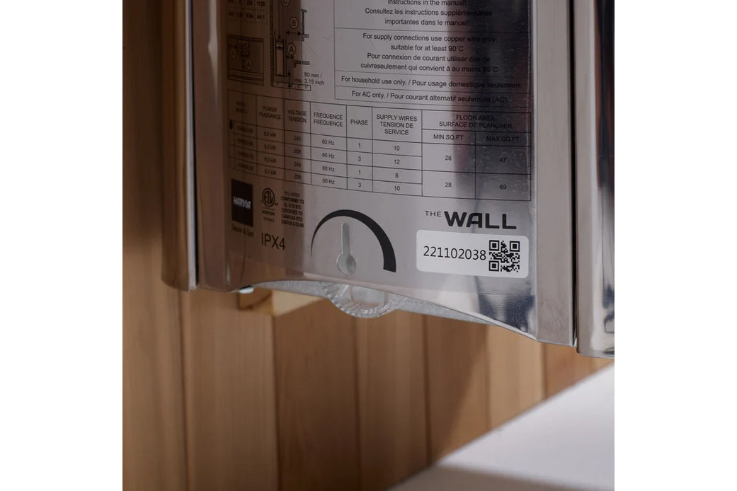 Close-up of sauna instruction label showing technical specifications table, IPX4 rating, QR code, and The Wall branding on me