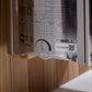 Close-up of sauna specifications label showing technical data table, QR code, and "The Wall" branding on white label affixed 