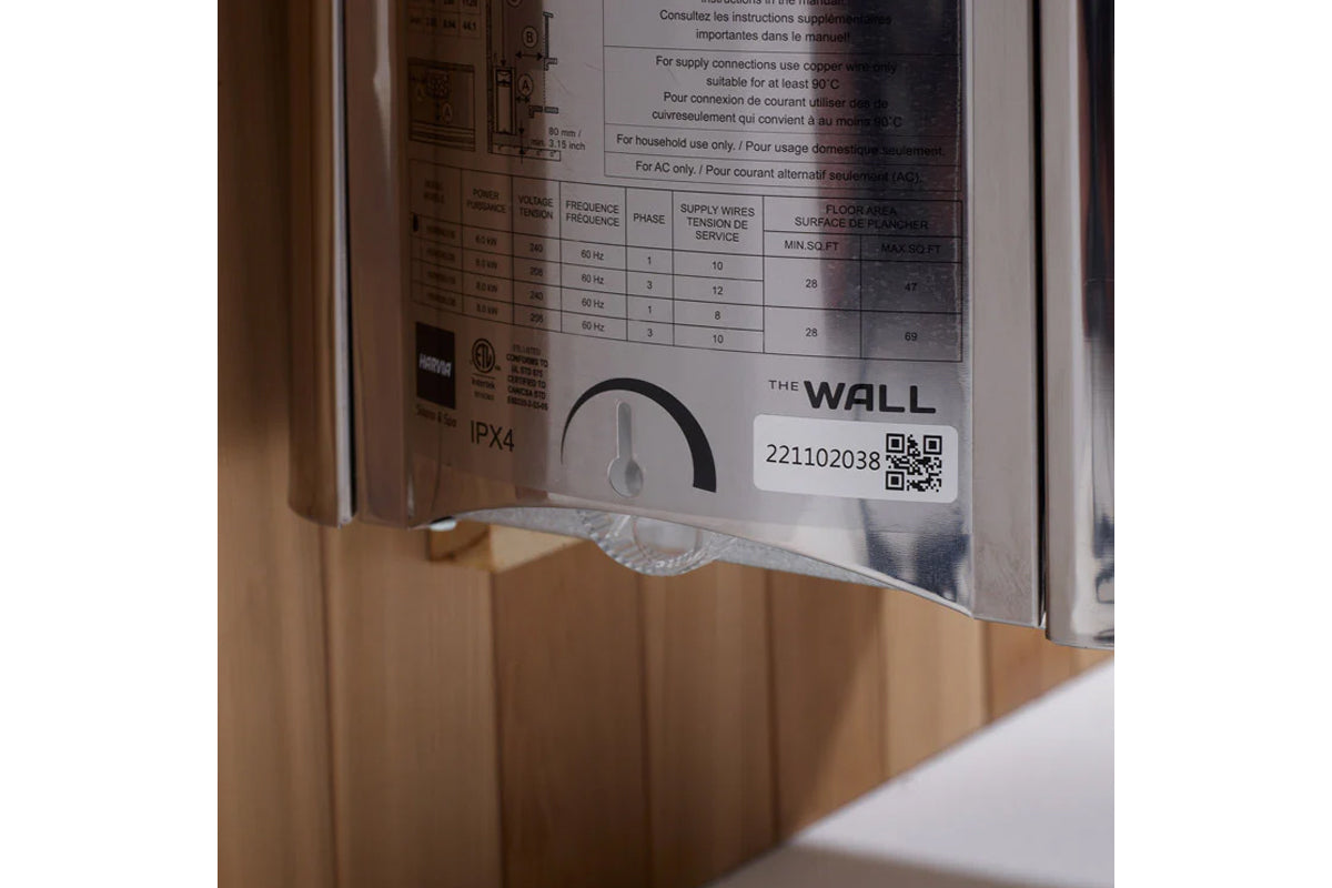 Close-up of sauna specifications label showing technical data table, QR code, and "The Wall" branding on white label affixed 