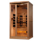 Light wood infrared sauna cabin with glass door, black interior heaters, and glowing amber salt bar at base, shown on white b