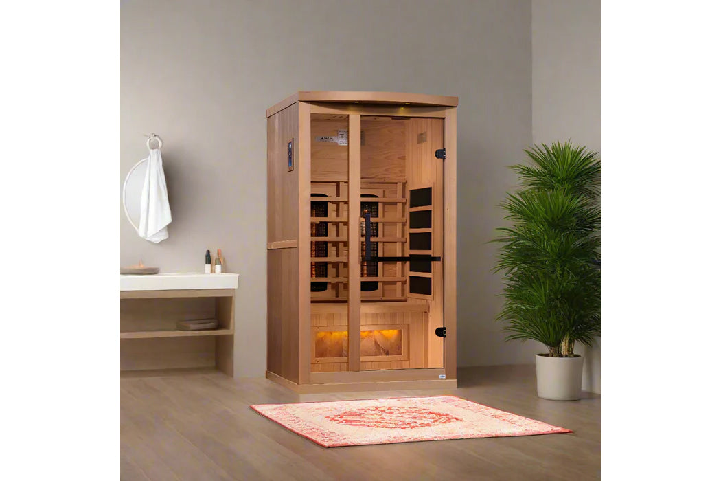 Cedar wood infrared sauna with glass doors and interior heaters, displayed in a bathroom setting with potted plant and vanity