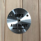 Polished stainless steel circular control panel with MP3 and AUX INPUT MAX 175mV text, mounted on wood background
